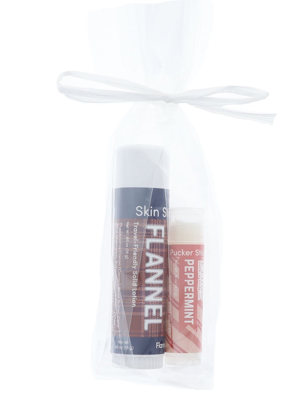 Flannel Skin Stick and Peppermint Pucker Stick tucked in sheer white mesh — gift duo on bright white