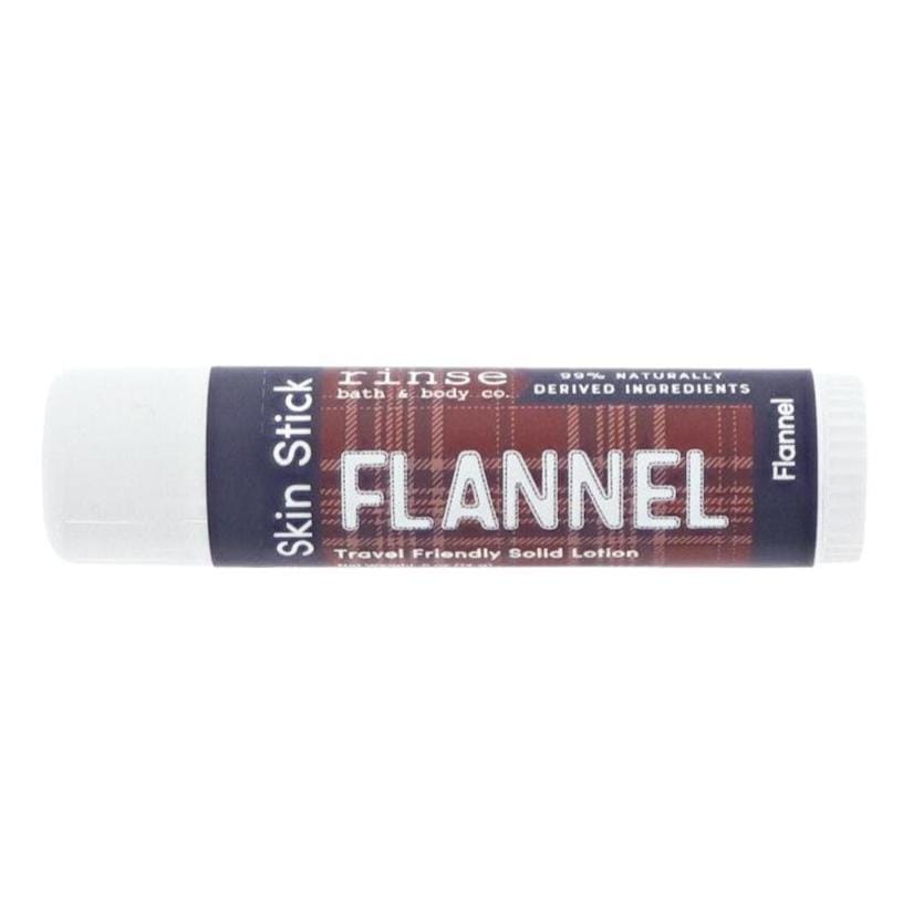 Flannel Skin Stick lying on bright white — maroon plaid label and navy ends in clean studio light