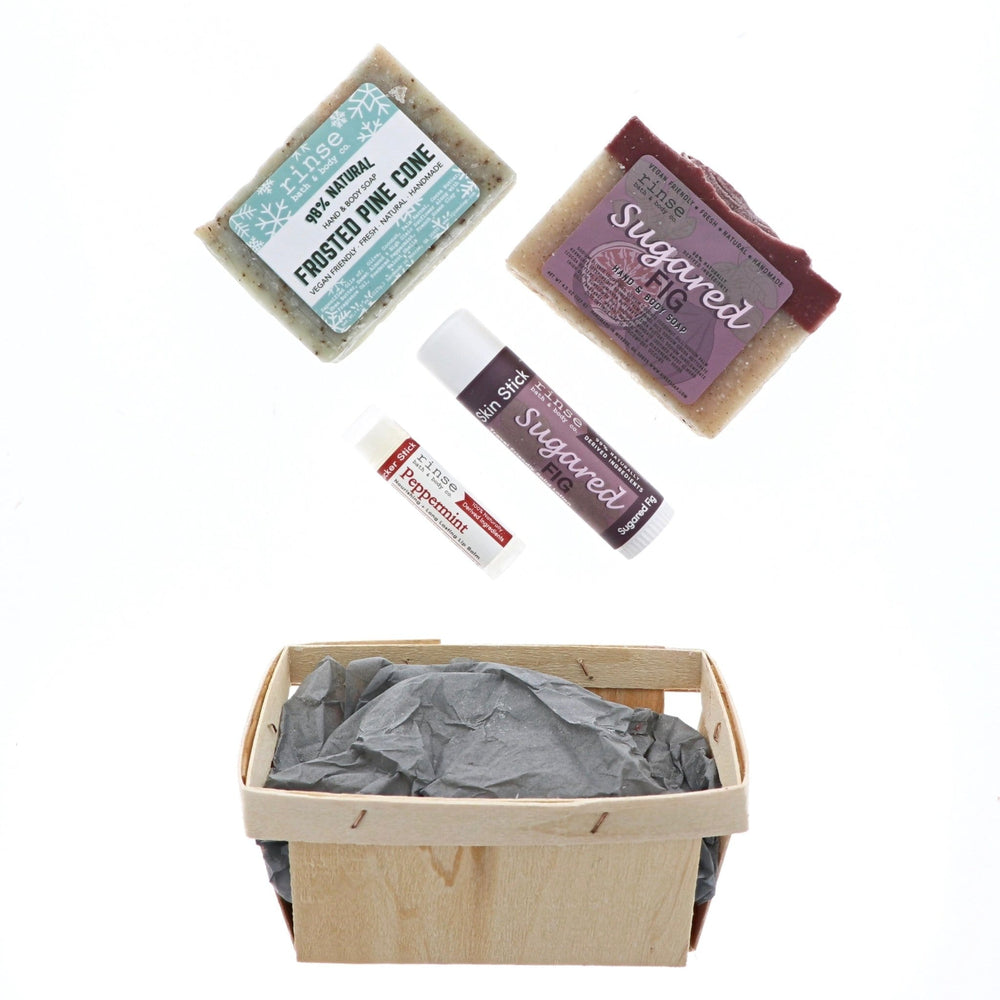 Frosted Pine and Sugared Fig products hovering over gray tissue in a berry till — bright minimalist holiday unbox