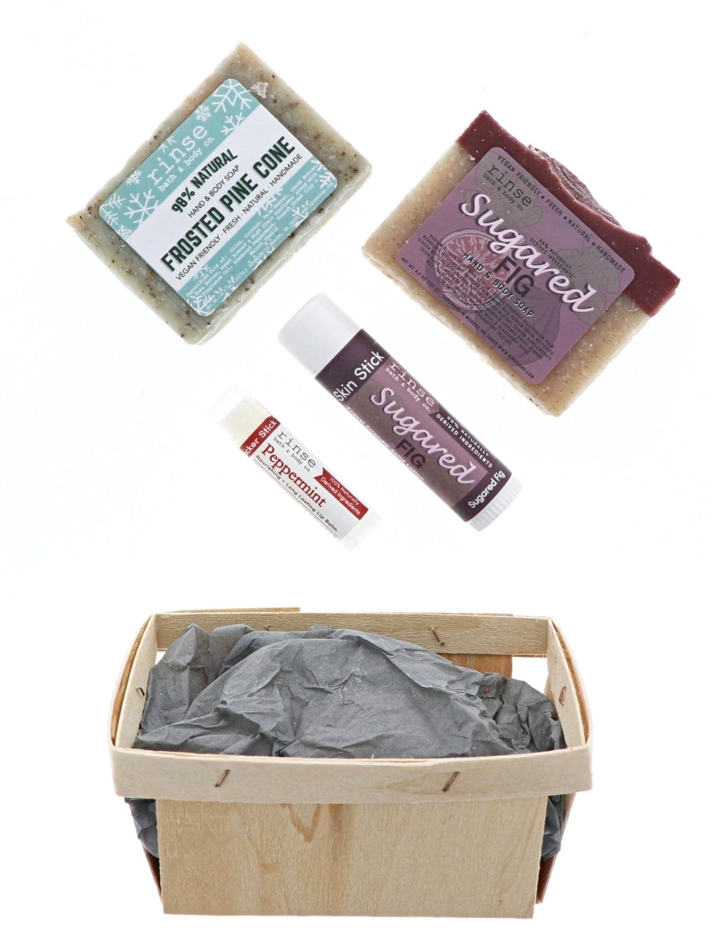 Frosted Pine and Sugared Fig products hovering over gray tissue in a berry till — bright minimalist holiday unbox