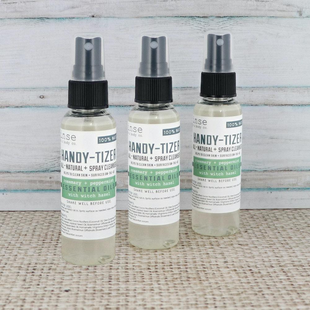 Three Rosemary Mint Handy-Tizer bottles staggered on burlap before weathered planks — cooling herbal spray cleanser