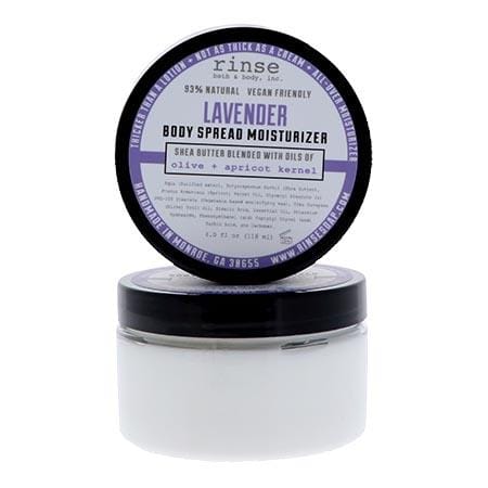 Lavender Body Spread jar with purple lid propped upright on bright white — thick white cream in clean studio light