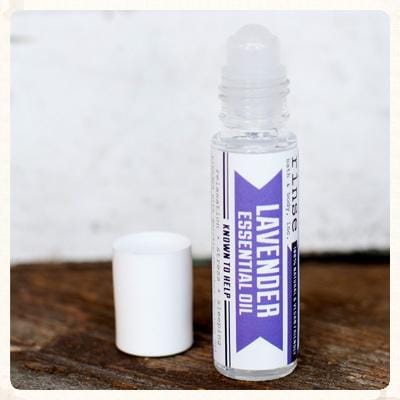 The Lavender Essential Oil Roll-On standing on weathered wood — 10 ml of Bulgarian lavender in squalane, sized for a pocket. Rinse Bath & Body Co.