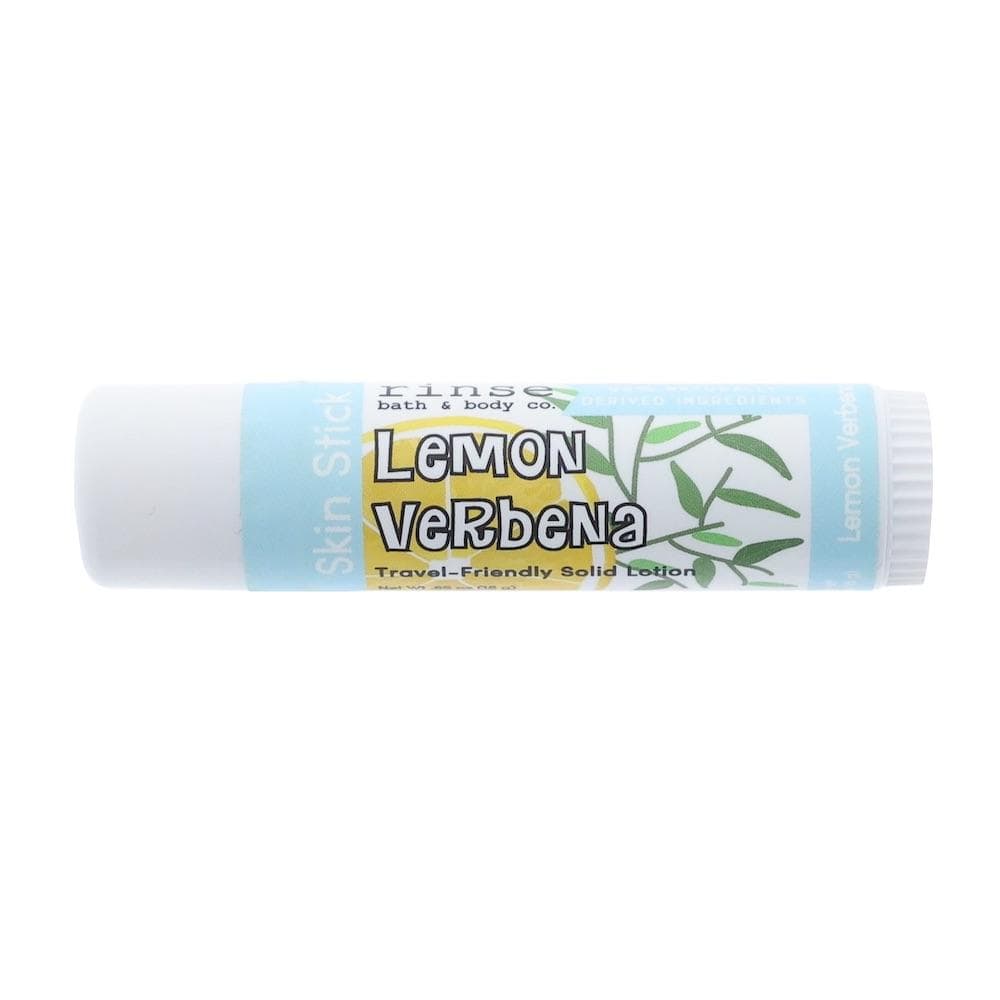 Lemon Verbena Skin Stick lying on bright white — leaf graphic label and travel tube in clean studio light