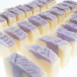 Rows of Lilac soap recede showing wavy purple tops — creamy bases in soft bright studio light