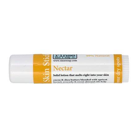 Nectar Skin Stick lying on bright white — sunny yellow-orange label in clean studio light