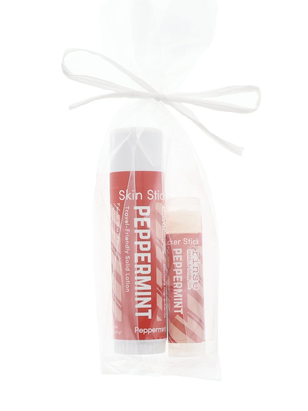 Peppermint Skin Stick and Pucker Stick nest in sheer white organza — candy-cane red labels and ribbon bow