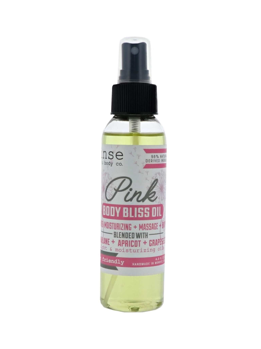 Pink Body Bliss Oil standing on bright white — clear spray of golden oil with pink label in clean studio light