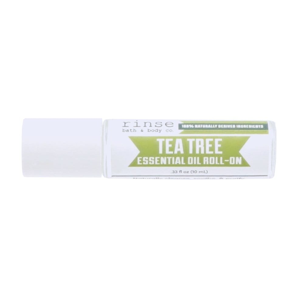 Tea Tree Essential Oil Roll-On lying on bright white — green banner label and white cap in studio light