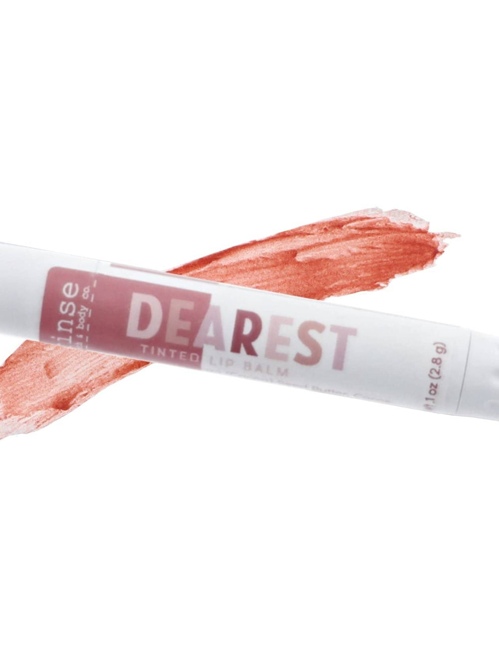 Dearest tinted lip balm tube beside a mauve swatch — creamy smear on clean bright white