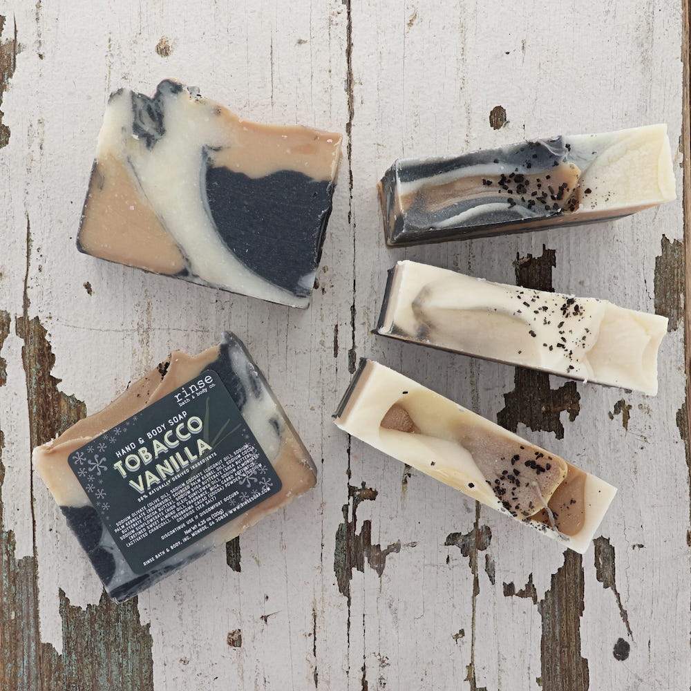 Close detail of the Tobacco Vanilla bar's dark poured surface and cream-swirled edge. Rinse Bath & Body Co.