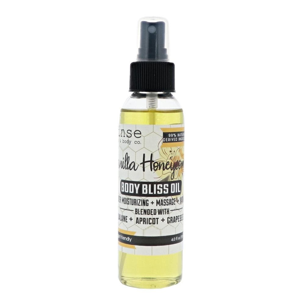 Vanilla Honeycomb Body Bliss Oil standing on bright white — pale yellow oil and yellow script label in studio light